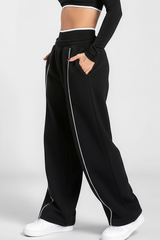 Women's black-bottomed casual pants with white stripes.